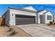 Charming single-story home featuring a dark gray garage door and a well-maintained gravel yard at 5180 E Diatomite Dr, San Tan Valley, AZ 85143