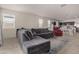 Spacious living room area featuring plush gray sofa that flows into open kitchen and dining spaces at 5180 E Diatomite Dr, San Tan Valley, AZ 85143