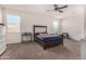 Spacious main bedroom with a ceiling fan, neutral carpet and a large bed frame at 5180 E Diatomite Dr, San Tan Valley, AZ 85143