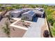 Aerial view of custom home featuring tile roof, solar panels, desert landscaping, and three-car garage at 5237 E Montgomery Rd, Cave Creek, AZ 85331