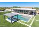 Aerial view of backyard featuring a pool, pergola, and sport court on an artificial grass lawn at 5237 E Montgomery E Rd, Cave Creek, AZ 85331