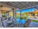 Inviting outdoor patio featuring wicker chairs, a pergola, and views of the large backyard with pool at 5237 E Montgomery Rd, Cave Creek, AZ 85331