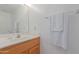 Simple bathroom features white sink, wooden cabinetry, large mirror, and white towels on towel rack at 6219 W Navajo Dr, Glendale, AZ 85302