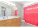 Bathroom featuring a double sink vanity and a shower with a red shower curtain at 6219 W Navajo Dr, Glendale, AZ 85302