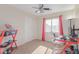 Bright bedroom featuring plush carpet, ceiling fan, large window, and study desk at 6219 W Navajo Dr, Glendale, AZ 85302