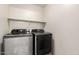 Modern laundry room featuring gray Samsung washer and dryer, with a shelf above at 8626 W Las Palmaritas Dr, Peoria, AZ 85345