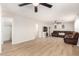 Bright living room features hardwood-style floors, ceiling fan, and comfortable brown leather reclining sofa at 8626 W Las Palmaritas Dr, Peoria, AZ 85345