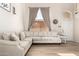 Bright living room with neutral decor, wood-look tile flooring, and a large window at 8626 W Las Palmaritas Dr, Peoria, AZ 85345