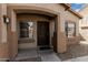 Close-up of a home's front entryway, featuring a dark wooden door and sidelight window at 9325 W Elwood St, Tolleson, AZ 85353