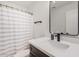 Modern bathroom featuring a stylish mirror, quartz countertop, and shower with striped curtain at 977 E Saratoga St, Gilbert, AZ 85296