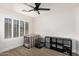 Bedroom with light wood floors, a black ceiling fan, and a bright window with white shutters at 977 E Saratoga St, Gilbert, AZ 85296