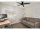 Bedroom featuring a fan, modern wallpaper, a sofa, desk, and laminate floors at 977 E Saratoga St, Gilbert, AZ 85296