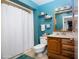 Bright bathroom with wood vanity, modern fixtures, and shower with curtain at 10106 W Highwood Ln, Sun City, AZ 85373