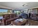 Cozy living room with golf course view, leather furniture, and ceiling fan at 10106 W Highwood Ln, Sun City, AZ 85373