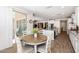 Bright breakfast nook with a round wooden table and four chairs, open to the kitchen and living room at 10547 E Relativity Ave, Mesa, AZ 85212