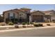 Inviting home with a stone-accented facade, well-maintained landscaping, and a paved driveway leading to the garage at 10547 E Relativity Ave, Mesa, AZ 85212