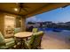 Covered patio with ceiling fan and furniture, provides a comfortable outdoor dining space overlooking the pool at 10547 E Relativity Ave, Mesa, AZ 85212