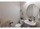 Elegant powder room with a decorative mirror, pedestal sink, and modern fixtures at 10547 E Relativity Ave, Mesa, AZ 85212