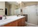 Well-lit bathroom featuring double sinks, a large mirror, and a glass-enclosed shower for a modern touch at 10817 W Swayback Pass, Peoria, AZ 85383