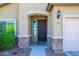 Stylish front door with stone accents and desert landscaping offers an inviting curb appeal at 10817 W Swayback Pass, Peoria, AZ 85383