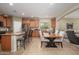 Spacious kitchen featuring an island with barstool seating and a dining area with a wooden table and chairs at 10817 W Swayback Pass, Peoria, AZ 85383