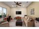 Cozy living room with plush seating, a ceiling fan, and a large window providing natural light at 10817 W Swayback Pass, Peoria, AZ 85383