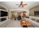 Open-concept living room connects to the kitchen, featuring a large TV and comfortable seating arrangements at 10817 W Swayback Pass, Peoria, AZ 85383