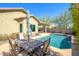 Inviting pool with an outdoor dining area set against a sunny sky at 10817 W Swayback Pass, Peoria, AZ 85383