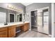 This primary bathroom features double sinks, vanity, sliding glass shower, and tile floors at 11029 W Oraibi Dr, Peoria, AZ 85373