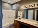 Bathroom featuring a dual sink vanity and a glass enclosed shower at 11029 W Oraibi Dr, Peoria, AZ 85373