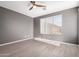 Comfortable bedroom with wood-look floors, neutral paint, a ceiling fan, and a bright window at 11029 W Oraibi Dr, Peoria, AZ 85373