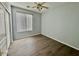 Bedroom with wood-look flooring, a ceiling fan, and a window at 11029 W Oraibi Dr, Peoria, AZ 85373