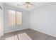 This bright bedroom features wood-look floors, a ceiling fan, and a window with natural light at 11029 W Oraibi Dr, Peoria, AZ 85373