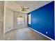 Bedroom featuring modern ceiling fan, stylish blue accent wall, and laminate flooring at 11029 W Oraibi Dr, Peoria, AZ 85373