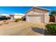 Exterior view of a home with a two-car garage, desert landscaping, and a well maintained driveway at 11029 W Oraibi Dr, Peoria, AZ 85373