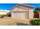 Exterior view of a home with a two-car garage, desert landscaping, and a well maintained driveway at 11029 W Oraibi Dr, Peoria, AZ 85373