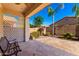 Inviting covered patio with stone flooring, bench seating, and a view of the lush backyard at 11029 W Oraibi Dr, Peoria, AZ 85373