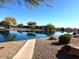 Scenic view of the neighborhood pond with lush greenery, trees, and peaceful surroundings at 11029 W Oraibi Dr, Peoria, AZ 85373