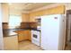 Classic kitchen with natural wood cabinets, tile backsplash, and white appliances at 1209 W 1St Pl, Mesa, AZ 85201