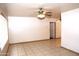 Neutral living area featuring tile flooring, a ceiling fan, and a large window at 1209 W 1St Pl, Mesa, AZ 85201