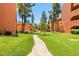 Lush green lawn with a charming brick pathway, complemented by the building's architecture at 12222 N Paradise Village S Pkwy # 405, Phoenix, AZ 85032