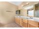 Double sink vanity in a well-lit bathroom with tile flooring, and private commode at 13025 W Gelding Dr, El Mirage, AZ 85335