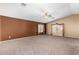 Large bonus room with neutral carpet and contemporary ceiling fan provides ample space at 13025 W Gelding Dr, El Mirage, AZ 85335