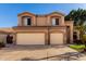 Inviting two-story home with a two-car garage, complemented by well-maintained landscaping and a clear blue sky at 13025 W Gelding Dr, El Mirage, AZ 85335