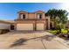 Inviting two-story home with a two-car garage, complemented by well-maintained landscaping and a clear blue sky at 13025 W Gelding Dr, El Mirage, AZ 85335