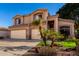 Charming two-story home featuring a two-car garage and mature palm trees in the front yard at 13025 W Gelding Dr, El Mirage, AZ 85335