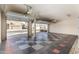 Spacious garage with an open door and checker-patterned floor is perfect for parking and storage at 13025 W Gelding Dr, El Mirage, AZ 85335