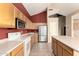 Well-lit kitchen with light wood cabinets, stainless steel refrigerator, white appliances, and tile floors at 13025 W Gelding Dr, El Mirage, AZ 85335