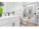 Well-lit bathroom showcases vanity, toilet, and bathtub with curtain and shelves at 13314 W Dale Ln, Peoria, AZ 85383