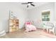 bedroom with a pink bed, shelves with toys, table and chair set, and paper flower decorations at 13314 W Dale Ln, Peoria, AZ 85383